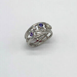 Platinum ring with three purple sapphires and diamonds