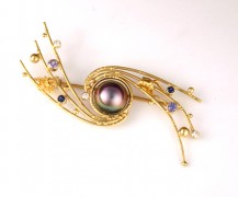 “Black Hole in the Center of a Spiral Galaxy” 18k and 22k gold with Black South Sea pearl, purple sapphires, diamonds