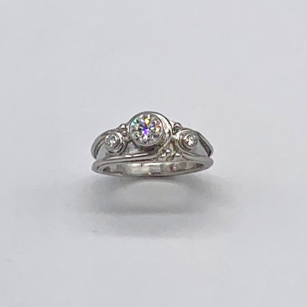 Platinum Lazare diamond ring has one flat side to sit against a plain band