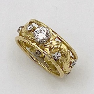18k yellow gold Elizabethan design band with platinum settings for all stones with a .52 ct., VVS1 clarity, F color Lazare Diamond with eight .o3 ct. E color, VS clarity diamonds around the band. The ring is 8 mm in width.