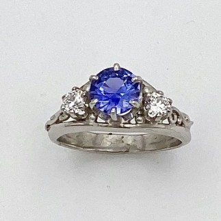 950 Platinum ring with a beautiful 1.04 ct. natural color purple/blue color shift sapphire flanked by .15 ct. diamonds, "E" color, VS clarity.