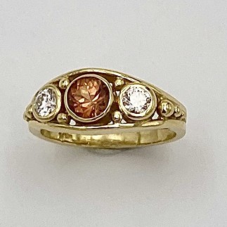 18k yellow gold ring with a natural color .94 ct. orange sapphire flanked by a .24 ct. ideal cut Lazare Diamond, "F" color, VS2 clarity on either side.