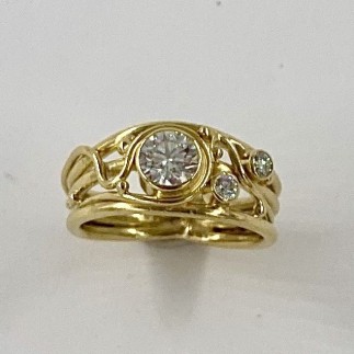 18k ring has a .44 ct. F color VS2 clarity ideal cut Lazare Diamond in the center and is flanked by two E color VS clarity ideal cut diamonds with a total weight of .09 ct.