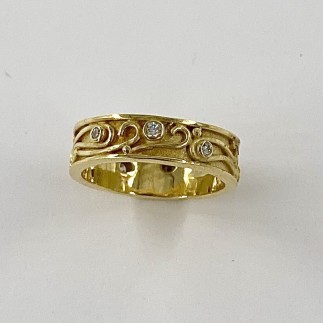 6mm wide, 18k yellow gold wedding band with 7 diamonds set all around. TW .19 ct., E color, VS clarity