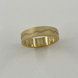 6mm wide 18k yellow gold ring with 18k palladium white gold river and a sandblasted finish.