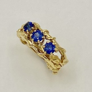 The three blue sapphires (H) in this ring have perfect 22k yellow gold rosebuds on either side of the gems.
