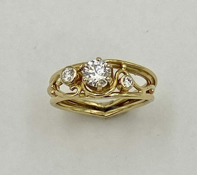A play on one of my favorite rings. 18k yellow gold with a .48 ct., E color, VS1 clarity ideal cut diamond in the center and flanked by a .08 ct. and .03 ct., 