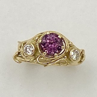 18k yellow gold looping wire and bead ring with a 1.39 ct., pinkish purple sapphire (H) with .15 ct. E color, VS clarity diamond on either side.