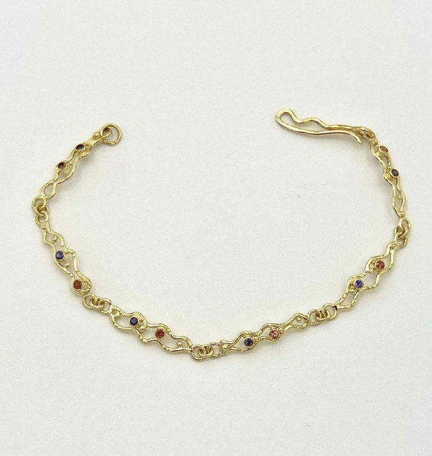 18k yellow gold link bracelet, 7.5 inches long with .27 cts. (TW) natural color orange sapphires and .22 cts. (TW) natural color purple sapphires.