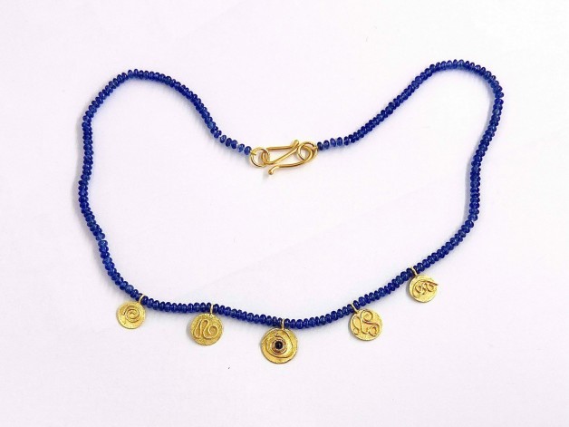 Blue sapphire (H) beads (52 cts. TW) with five 22k gold discs, 1 disc with a .32ct. blue sapphire cabochon. Measure 17 1/4 inches long.