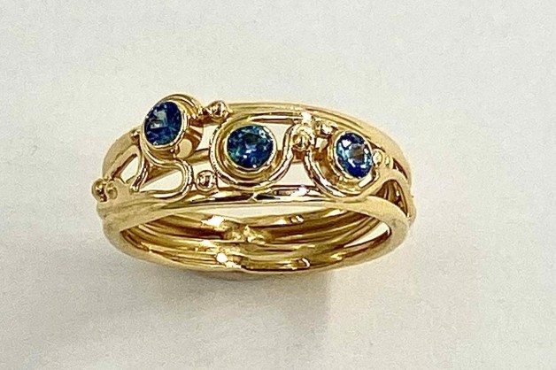 18k yellow gold hand built ring with three teal colored Montana sapphires .39ct (TW) (H)