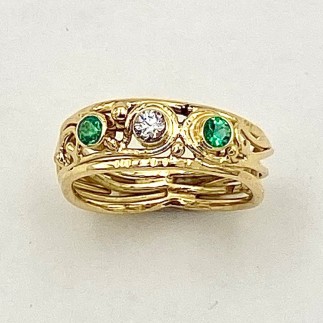 18k yellow gold ring with a .11ct. E color, VS clarity diamond and two emeralds (O) .17ct.(TW).