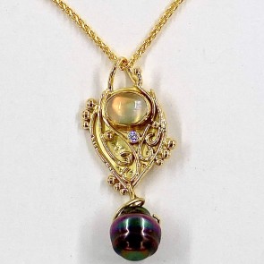 18k yellow gold pendant with a 3.35 ct. original source rainbow moonstone with a 22k bezel setting, a .05 ct. diamond E color, VS clarity and a black South Sea pearl. Chain is priced separately.