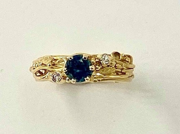 18k yellow gold ring with a .65 ct. Montana sapphire with two .03 ct., E color, VS clarity diamonds.