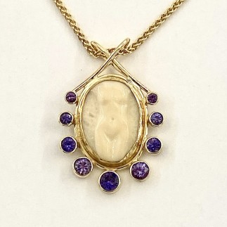 18k yellow gold pendant with a hand carved fossilized walrus tusk set in 22k gold with nine purple sapphires, t.w. 2.00 ct. Carving by Lisa Bialac-Jehle. One of a kind pendant to match the Naked Lady Earrings. A one of a kind piece no one else in the world owns!