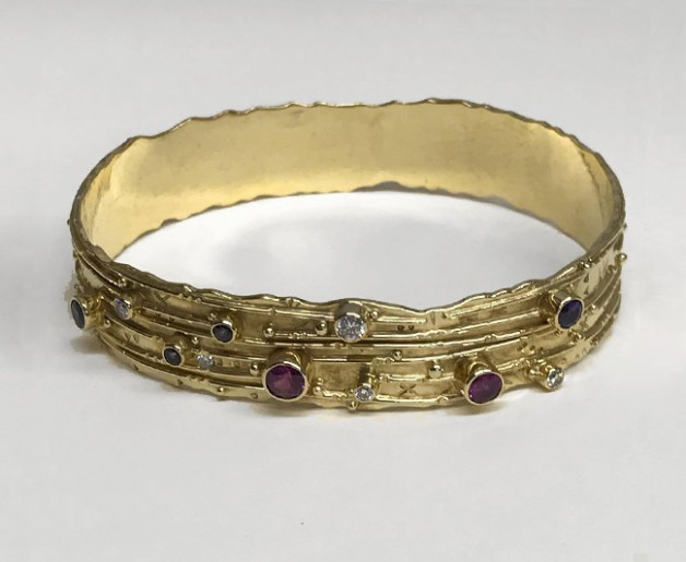 custom gold bracelet with many sapphires and diamonds