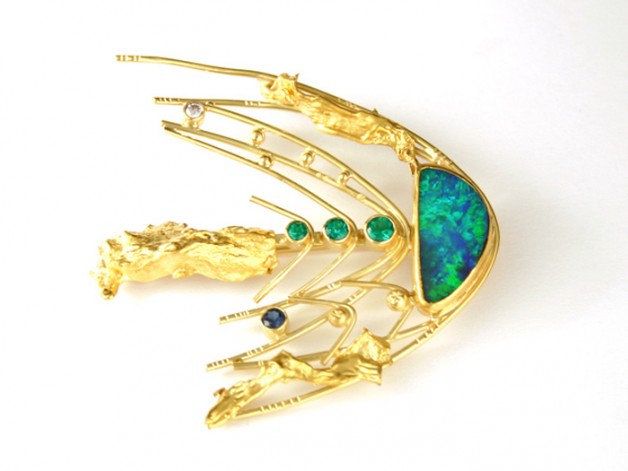Daniel R. Spirer Jewelers, Boston, offers this 18k and 22k gold comet pin with boulder opal, emeralds, sapphire and diamond